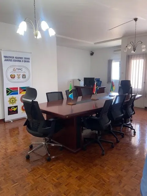 The TPC boardroom in Maputo: the roll-up banner “Together against crime · Juntos contra o crime” and the three member-state flags